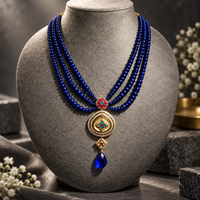 Multi-layer blue beaded necklace with a Jadau pendant.