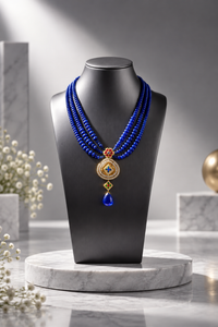 Multi-layer blue beaded necklace with a Jadau pendant.
